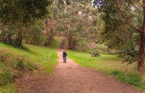 child riding bike along the trail at the Yarrowee River