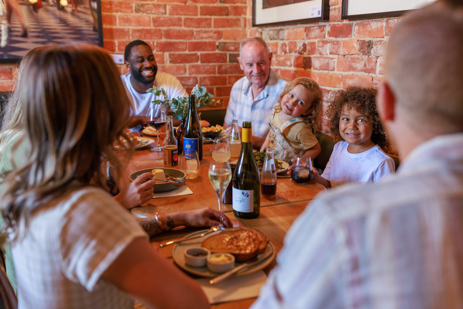 Generic photo group of people around a table sharing food and conversation