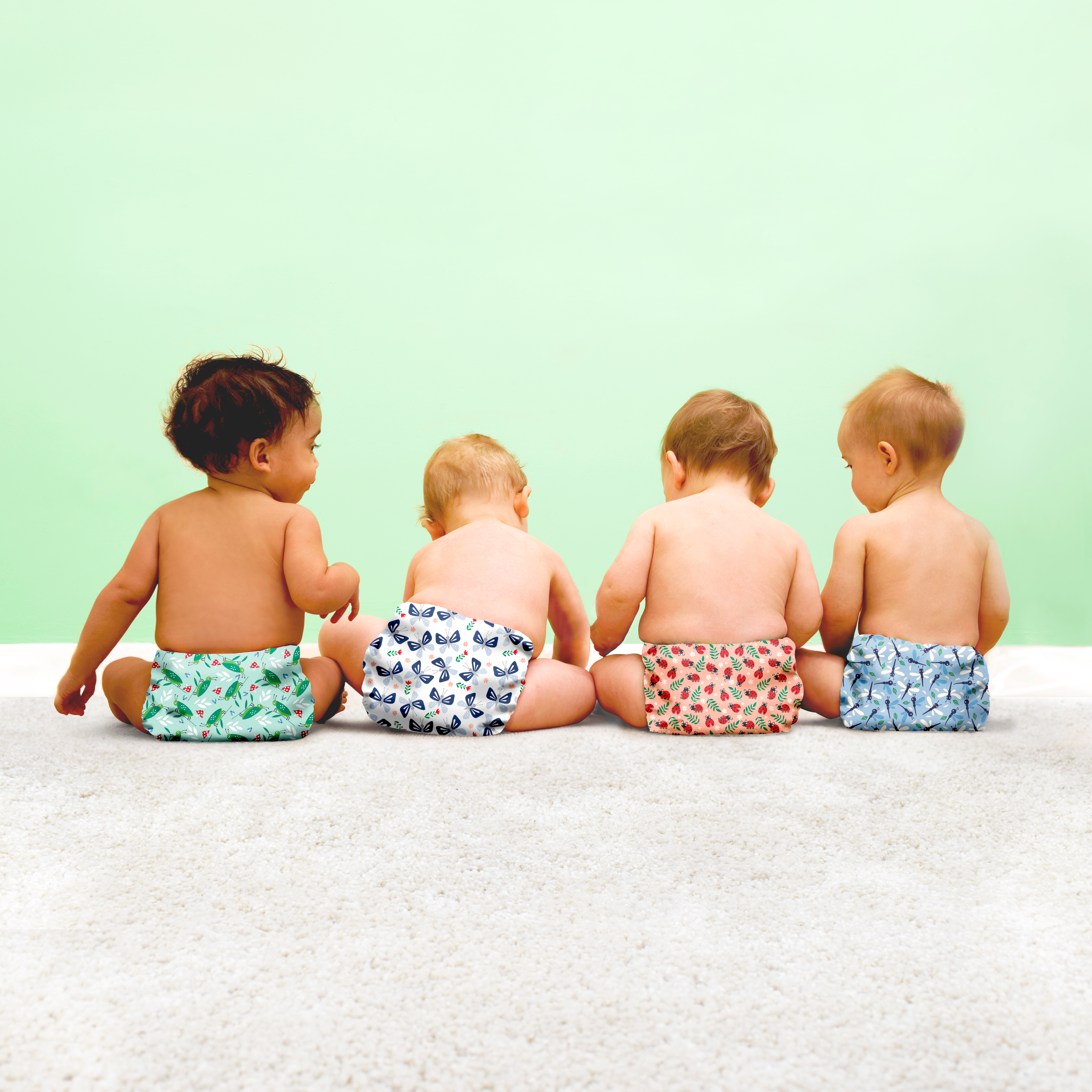 four babies wearing reusable modern cloth nappies