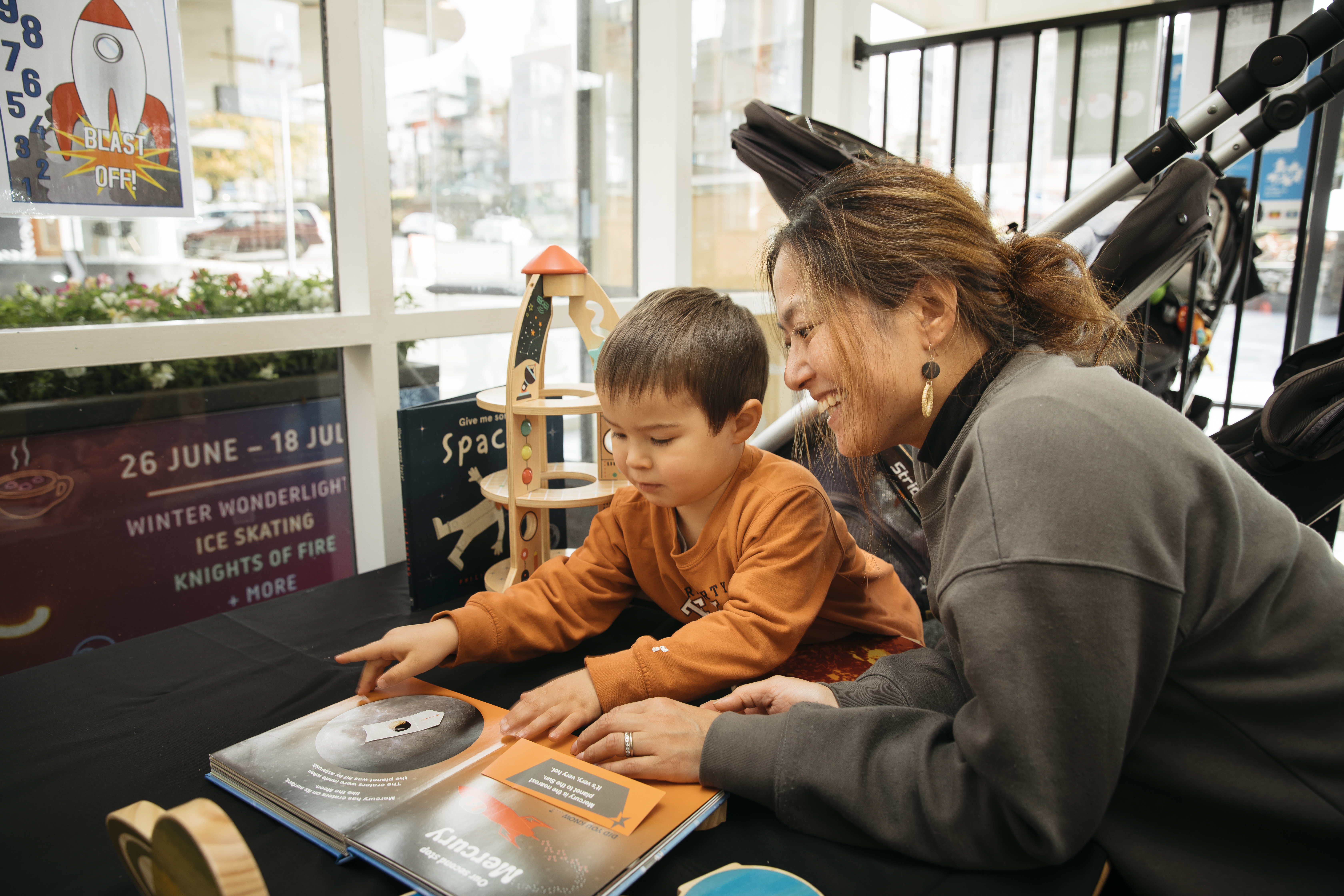 A woman reading a book with a young child