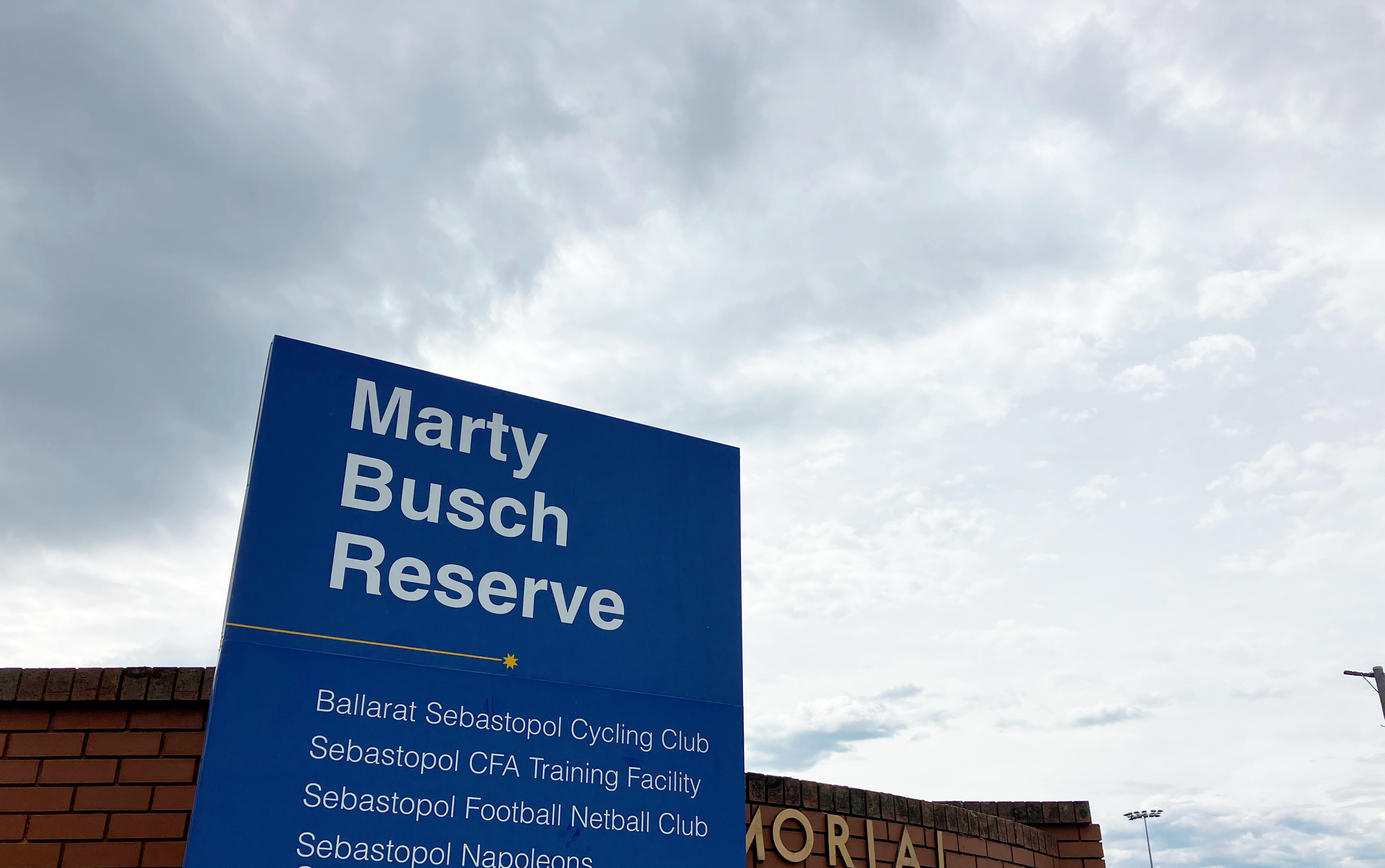 Blue Marty Busch signage with sky in background 