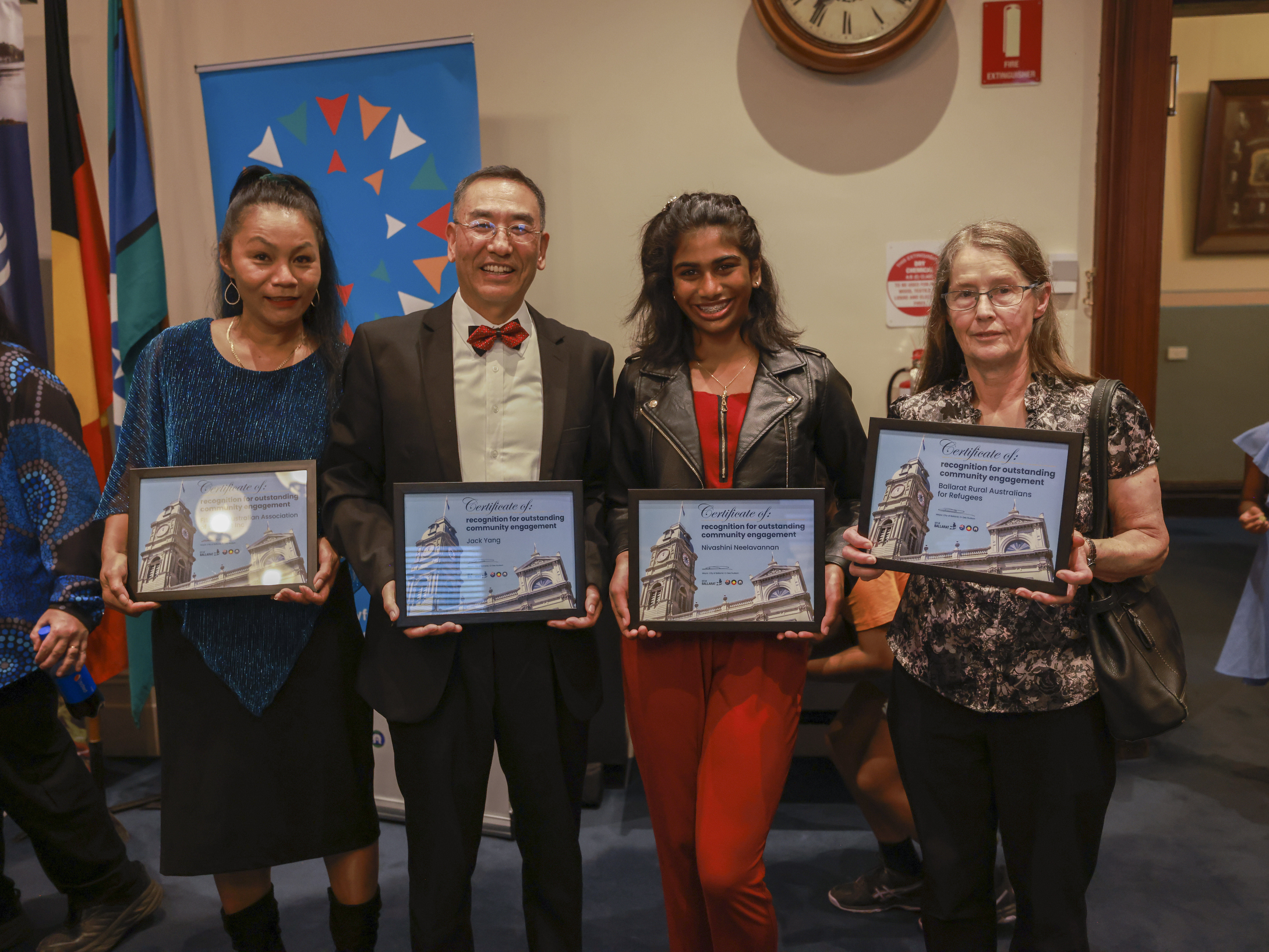 Photo of four winners holding up their framed certificates at the Intercultural Awards in 2023