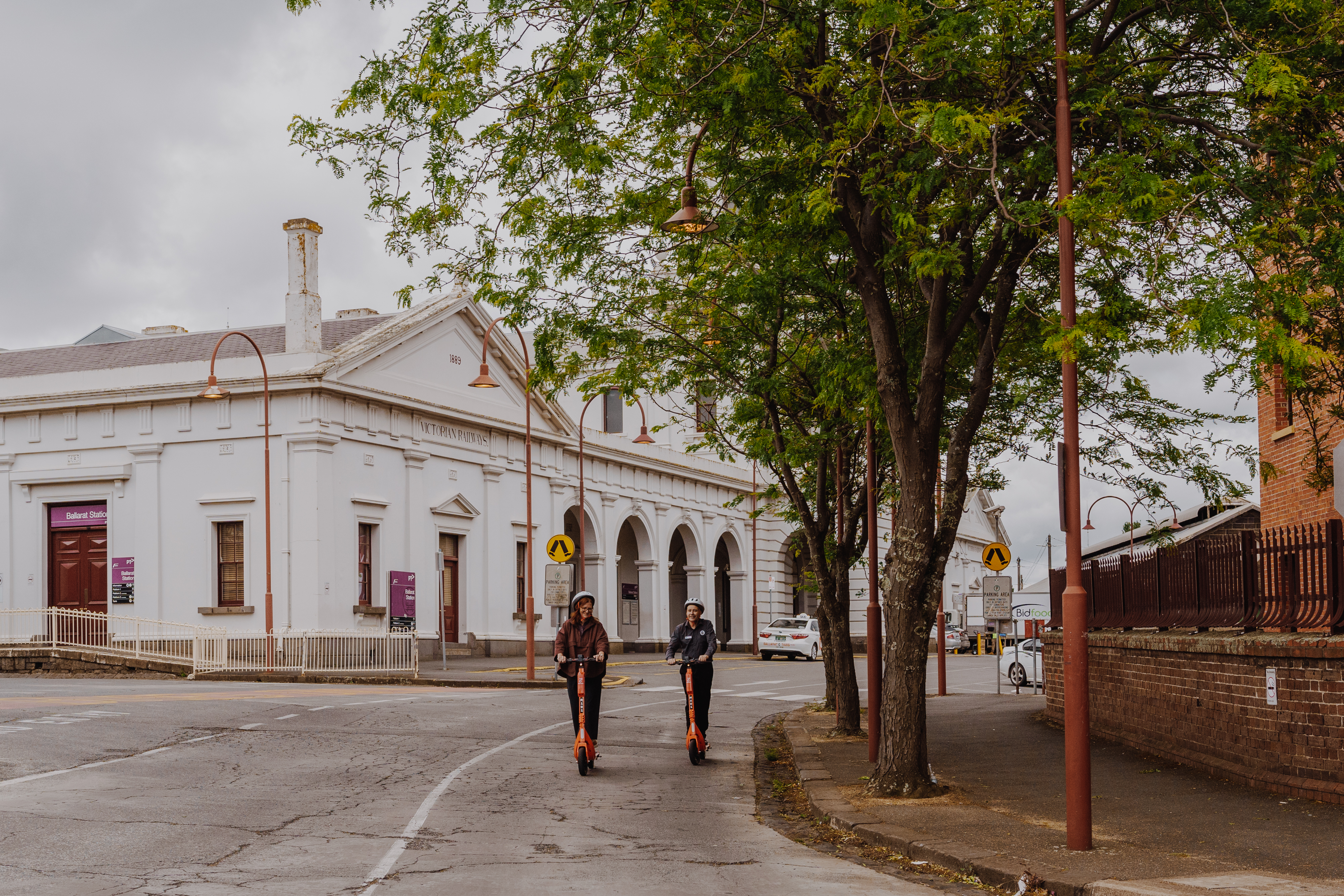 Generic image of two people using e-scooters Ballarat Train Station