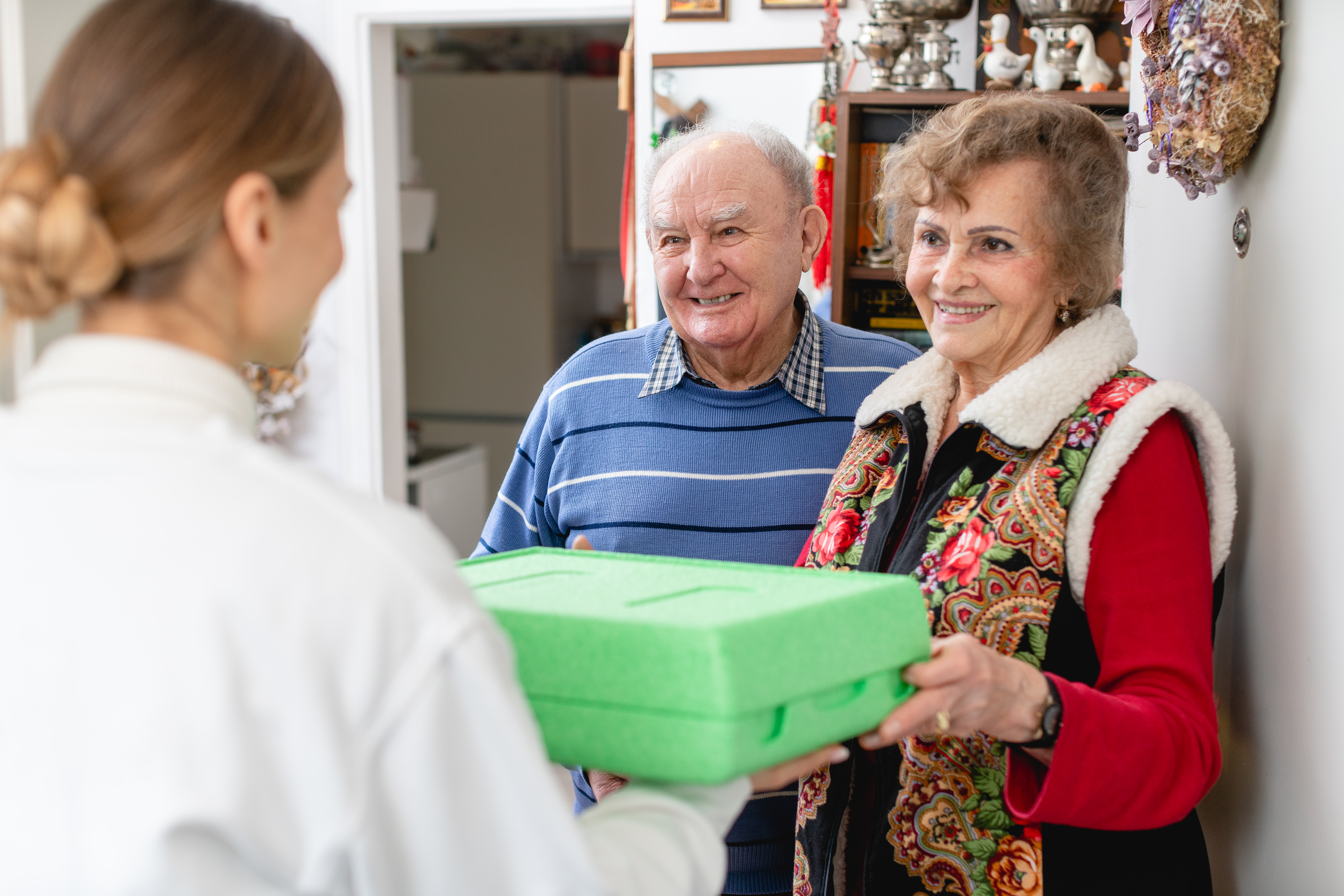 Elderly couple receiving a meal at doorstep