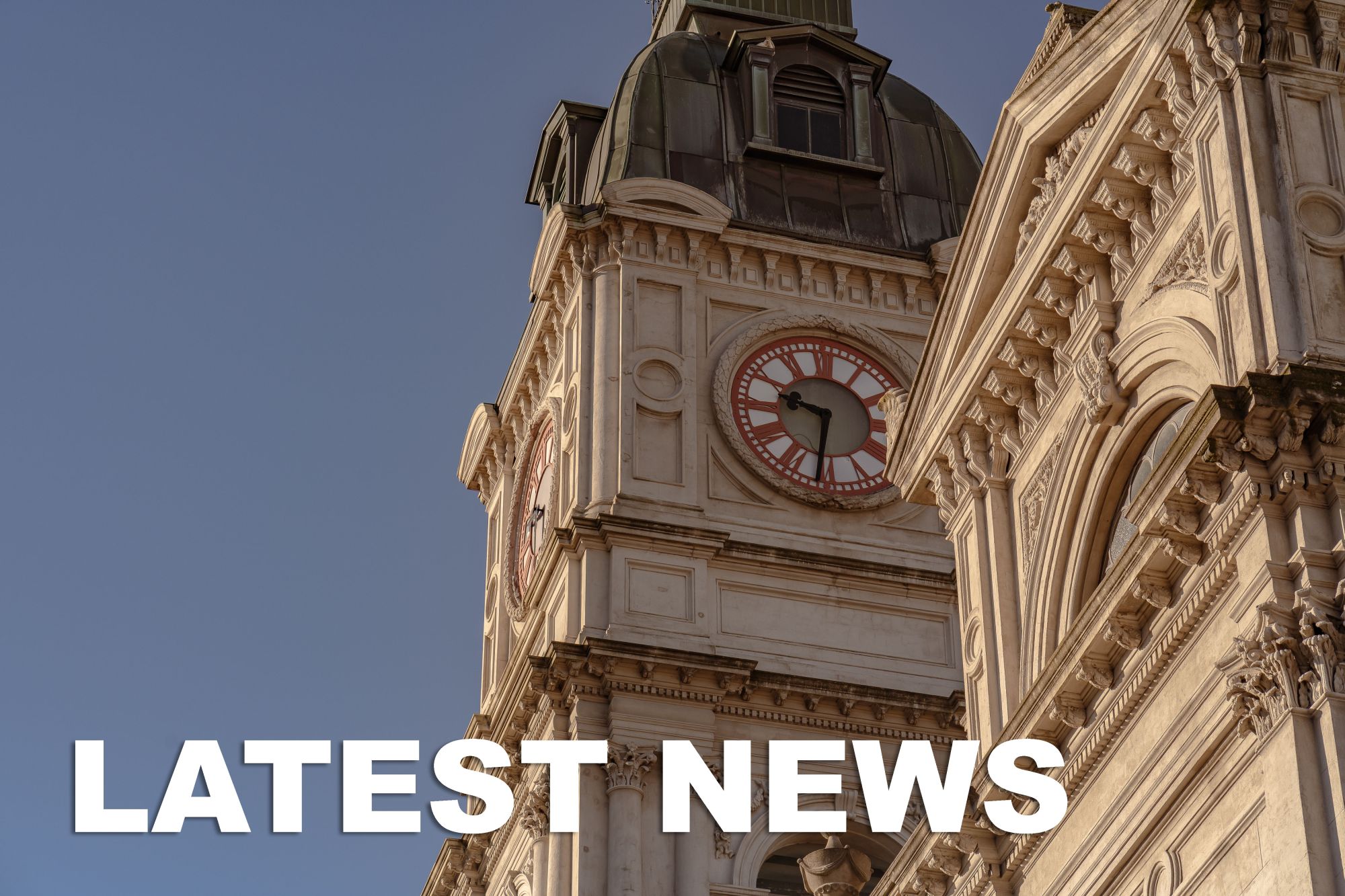 Town hall clock up close with "latest news" written at the bottom