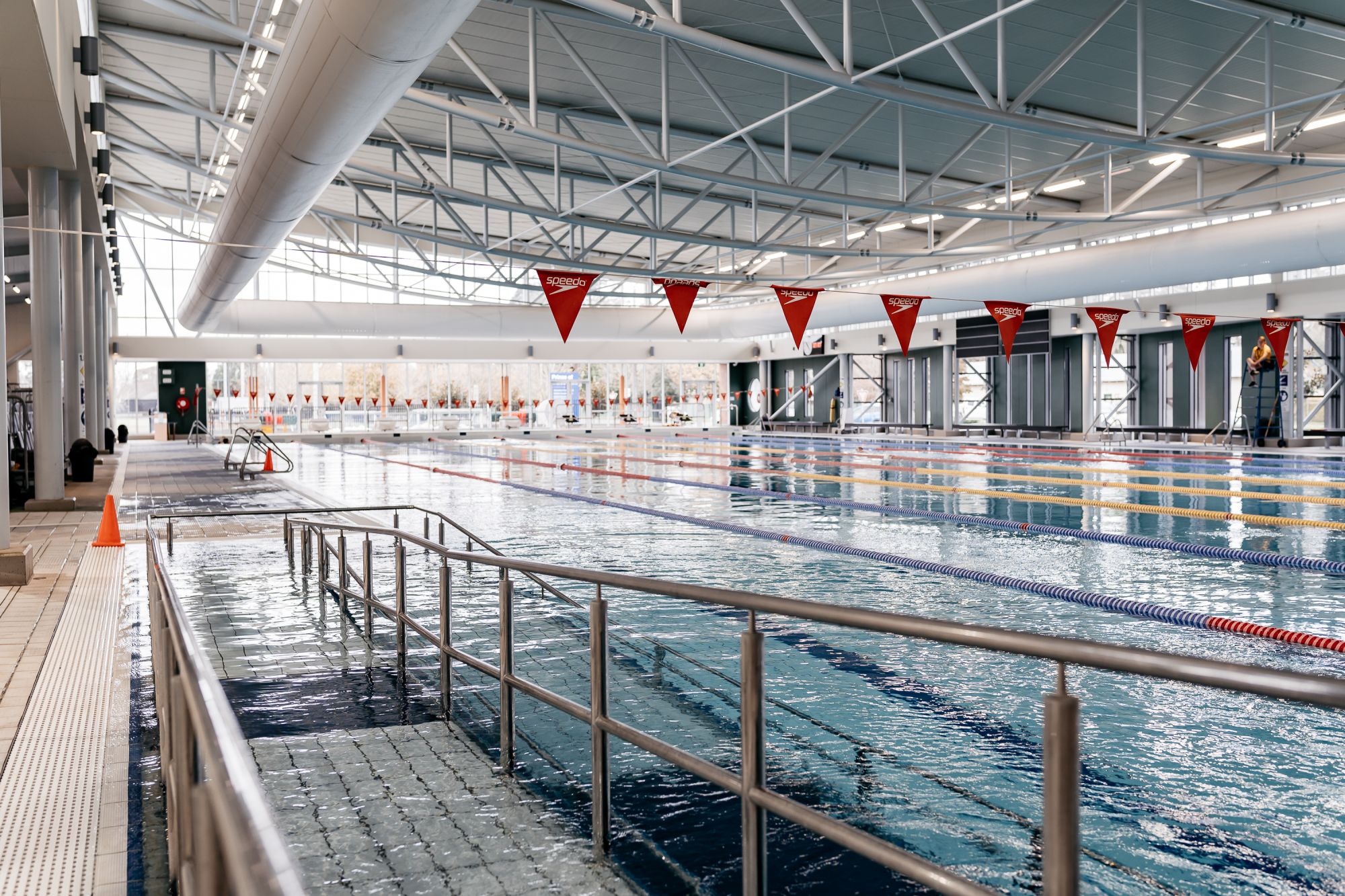 In the foreground is a walkway into a pool and in the background is the pool. 