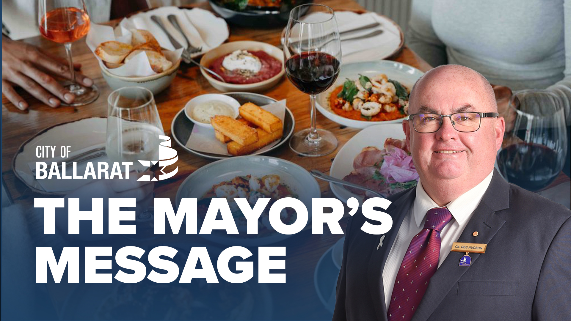 Text with The Mayor's Message with an image of Mayor Cr Des Hudson in front of a table of food and wine