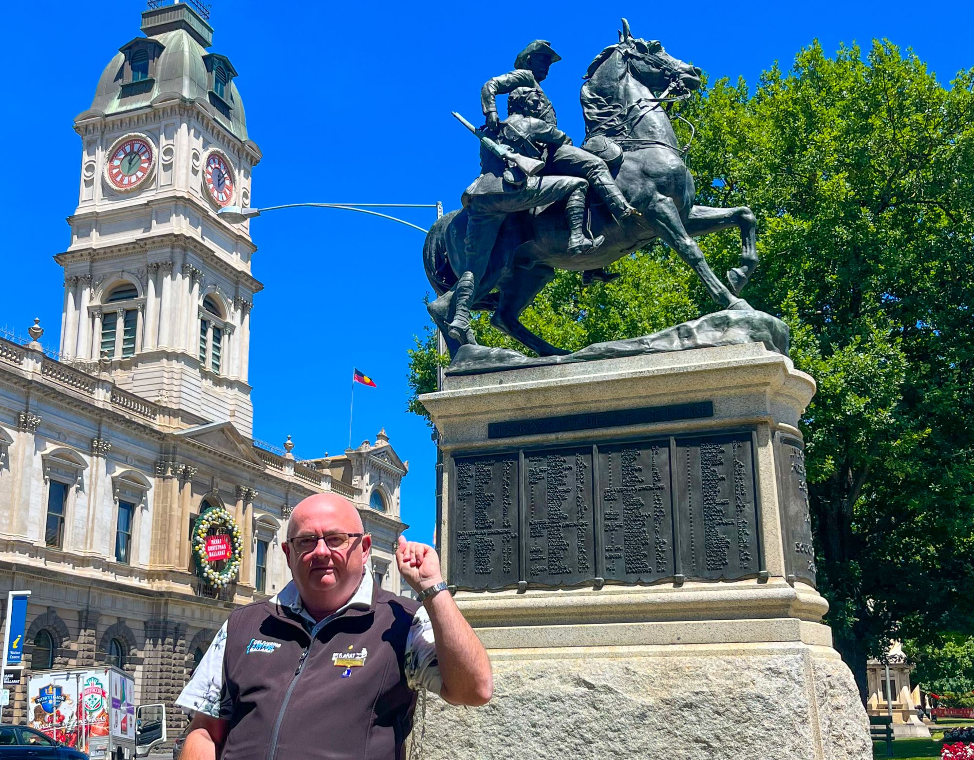 Mayor Cr Des Hudson standing in front of the Boer War Memorial Statue in Sturt Street with Town Hall in the background.