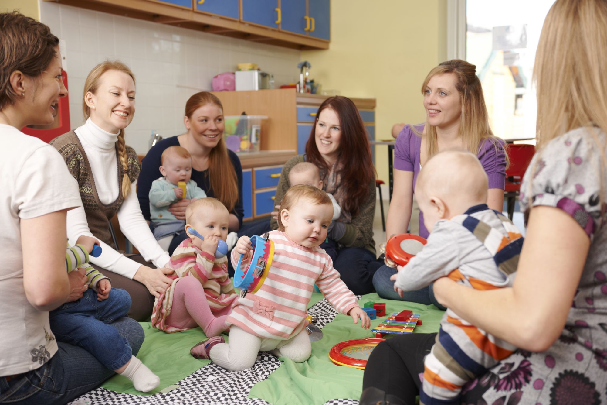 Group of mothers playing with babies