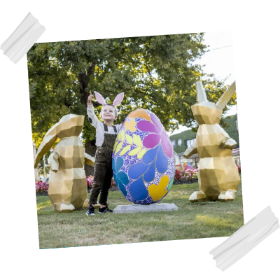 Child in the Sturt Street gardens with the easter decorations, painted egg and geometric bunny statues