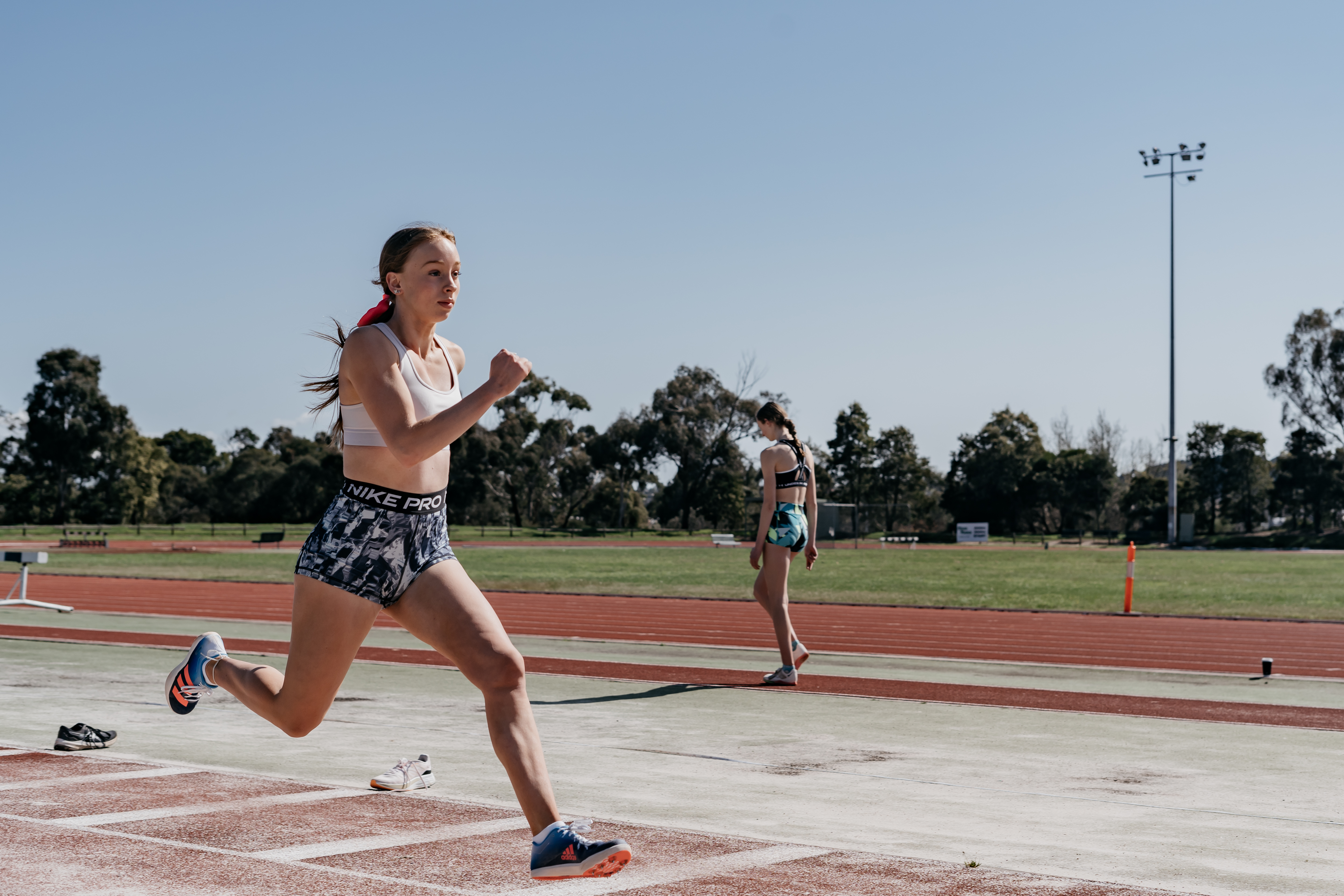 a girl running on an athletics track
