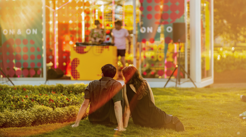 People sitting on the grass listening to music at the Boom Box