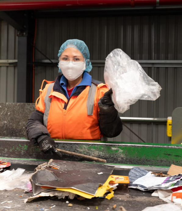 Plastic pollution: Australian Paper Recovery staff manually remove plastic bags from the conveyor belt to prevent recyclables being contaminated.