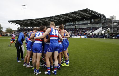 Western Bulldogs AFL players huddle before the start of a game at Mars Stadium