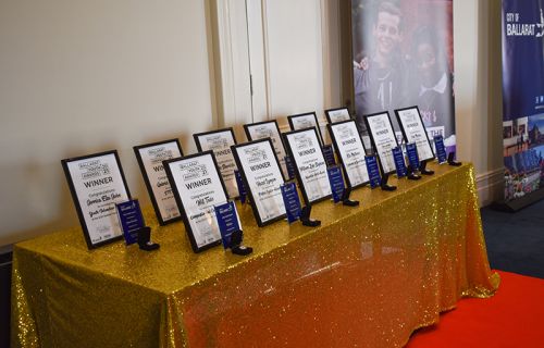 Award certificates lined up on a gold table