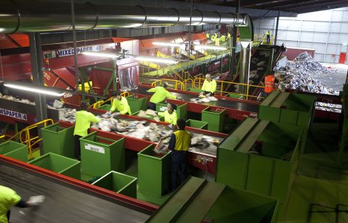 Works sorting rubbish in a Materials Recovery Facility