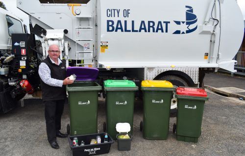 Mayor Des Hudson with four bins in front of a rubbish truck