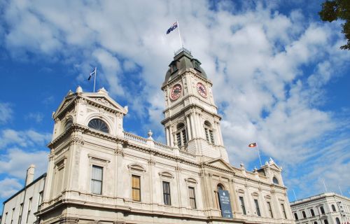 The image looks up at Ballarat Town Hall with a blue sky dotted with clouds in the background. 