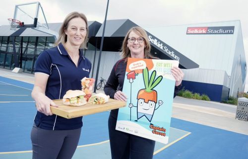 City of Ballarat Health Promotion Officer Natalie Grero holds a tray of healthy food and Ballarat Community Health Healthy Communities Coordinator Melissa Farrington holds a poster. 