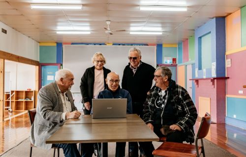 Group of community members around a computer