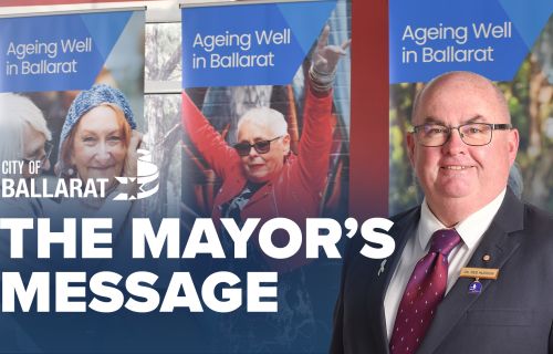 Text with The Mayor's Message with an image of Mayor Cr Des Hudson in front of Seniors Festival signage