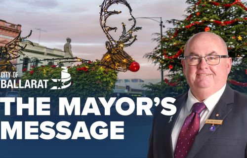 Text with The Mayor's Message with an image of Mayor Cr Des Hudson in front of the Ballarat Christmas display