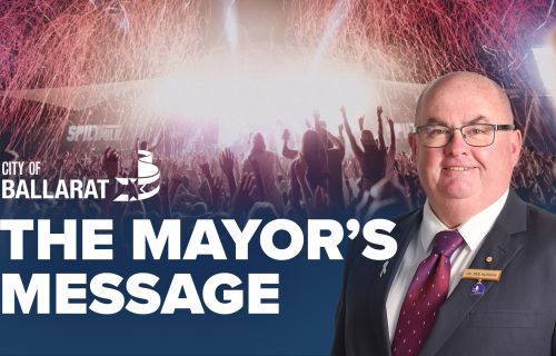 Text with The Mayor's Message with an image of Mayor Cr Des Hudson in front of the Spilt Milk Festival