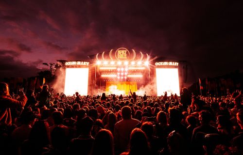 The Spilt Milk stage is lit up behind a dark night sky. 