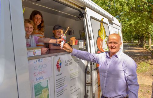 Cr Peter Eddy with children at Victoria Park receiving an ice cream