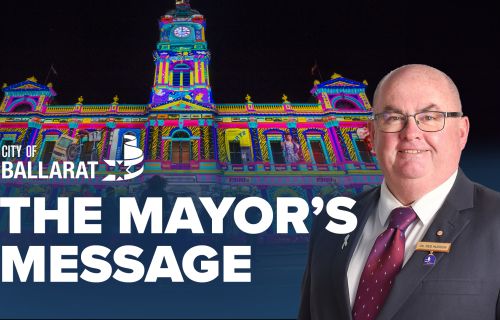 Text with The Mayor's Message with an image of Mayor Cr Des Hudson in front of the Town Hall display for White Night