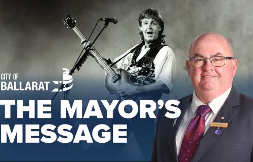 Text with The Mayor's Message with an image of Mayor Cr Des Hudson in front of an image of Paul McCartney