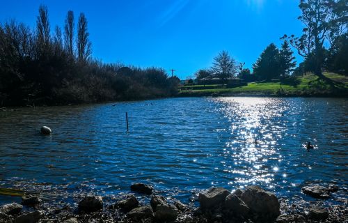 Photo of Gong Dam in Buninyong, sparking water in foreground and bright sky