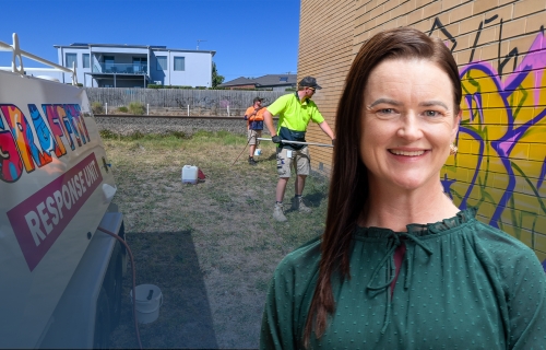 Image of Mayor Cr Tracey Hargreaves in front of the Graffiti Response Unit tending to a  graffitied brick wall