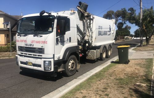 Rubbish truck collecting bins in a residential street