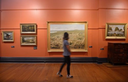 Image of a girl walking through the gallery admiring the artwork