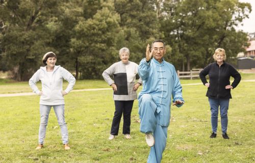 man leading three ladies in a class of Tai Chi outdoors