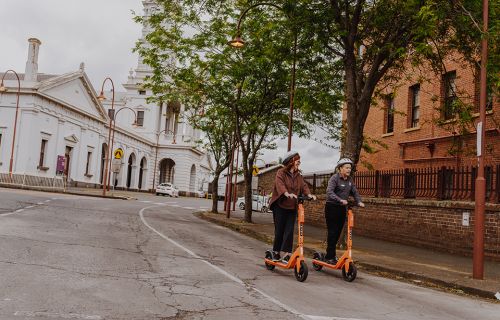 City of Ballarat Visitor Economy Executive Manager Sarah Pilgrim and Visitor Services Officer Paul Mifsud explore Ballarat on e-scooters.