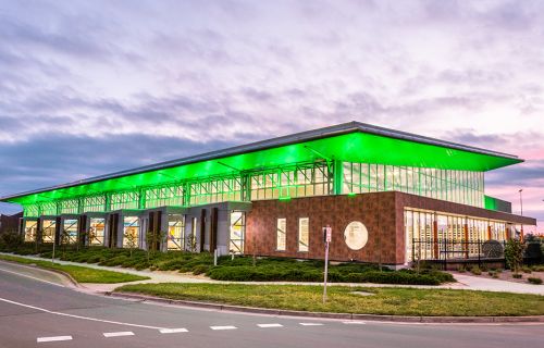 Exterior photo of BALC with green lighting at dusk