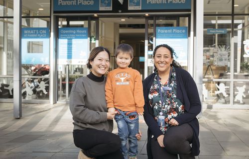 Two women and a child outside the parent place building on Sturt Street