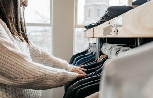 A woman looking through clothes on a rack