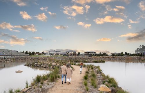 people walking on a path between two bodies of water