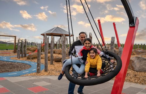 a family on a swing in a playground