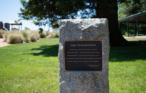 A plaque on a stone pillar in a park