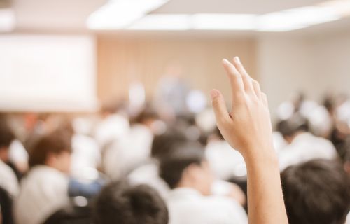 A hand raised during a meeting