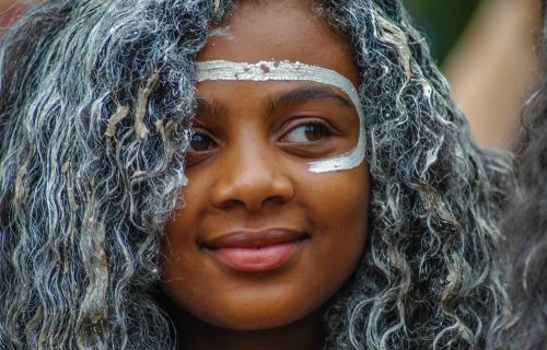 close up of a young indigenous girl with white paint on her face