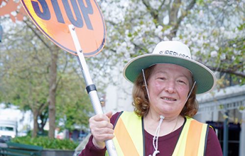 Older woman holding a stop sign 