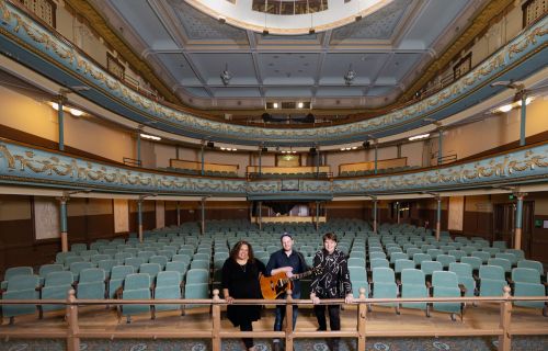 three performers from the resurgence show sitting in the front seats of the theatre