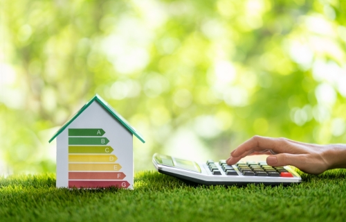 green background with a house showing an efficiency scale and someone using a calculator presumably calculate cost savings