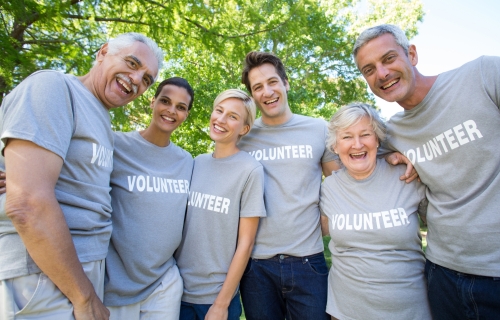 Happy volunteer family smiling at the camera on a sunny day