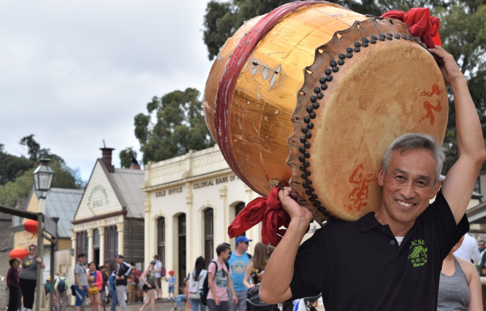 Image of a Chinese man carrying a drum